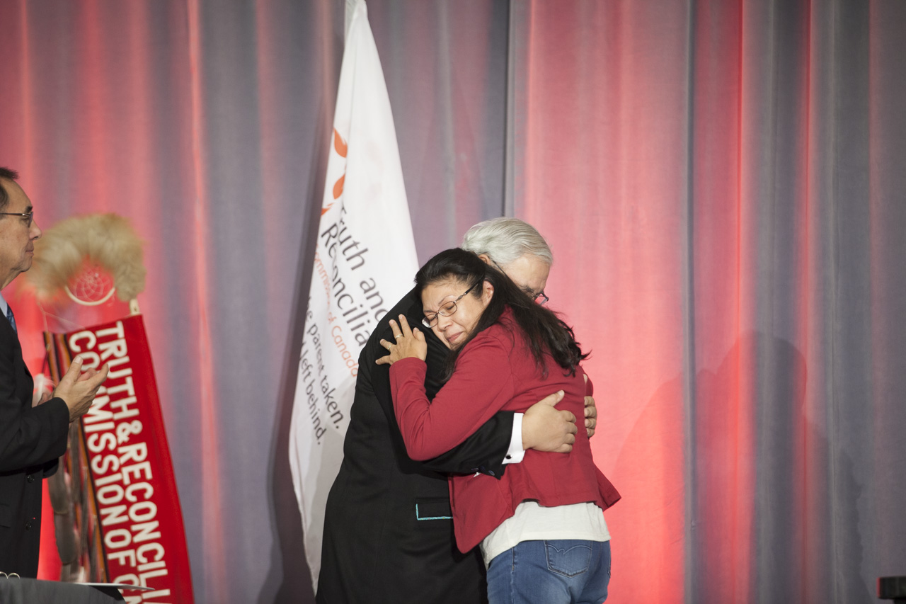People hugging on stage at TRC of Canada's Closing Ceremony