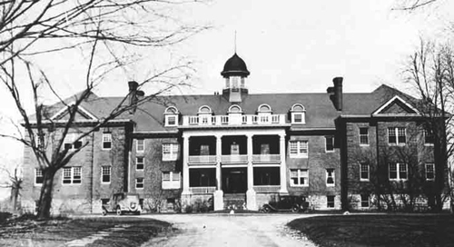 L’Institut Mohawk à Brandford, en Ontario. Bâtiment de trois étages avec une entrée à colonnes, quatre cheminées et une coupole au sommet.