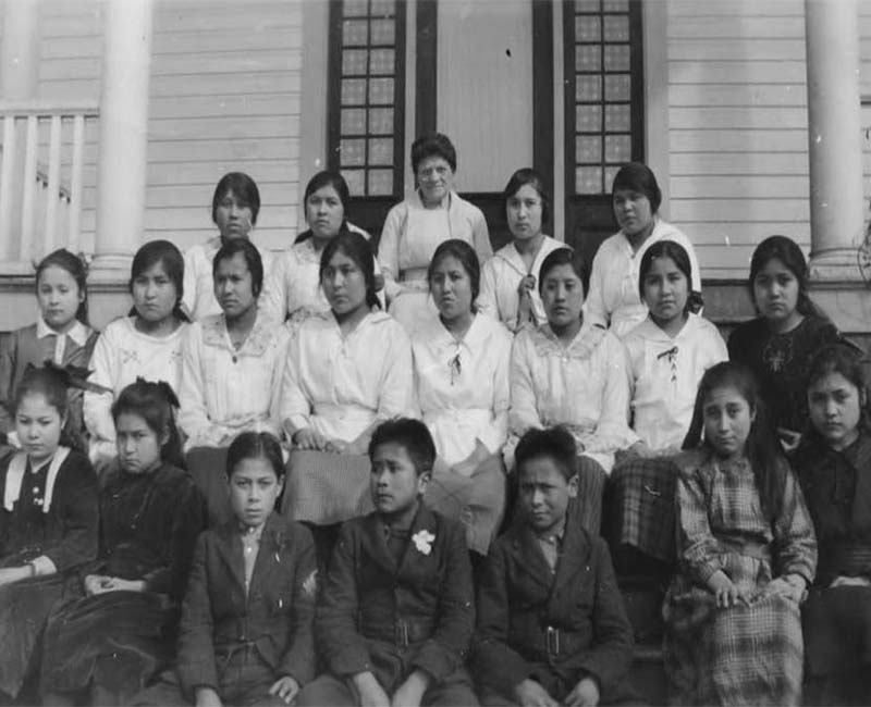 Group of students sitting outside on steps from Port Simpson Crosby Home for Girls