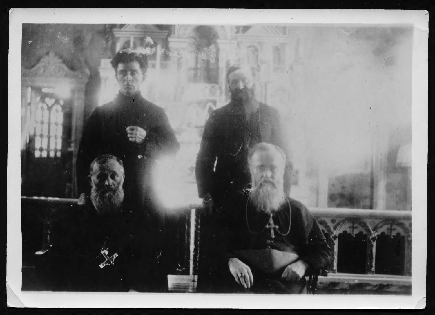 Monseigneur Ovide Charlebois and other priests pose for the camera in front of an altar in 1916.