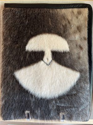 A publication titled "First Canadians, Canadians First: The National Strategy on Inuit Education" by ITK, housed in a distinctive black leather and sealskin folder featuring a "Kiluk, LTD" patch.